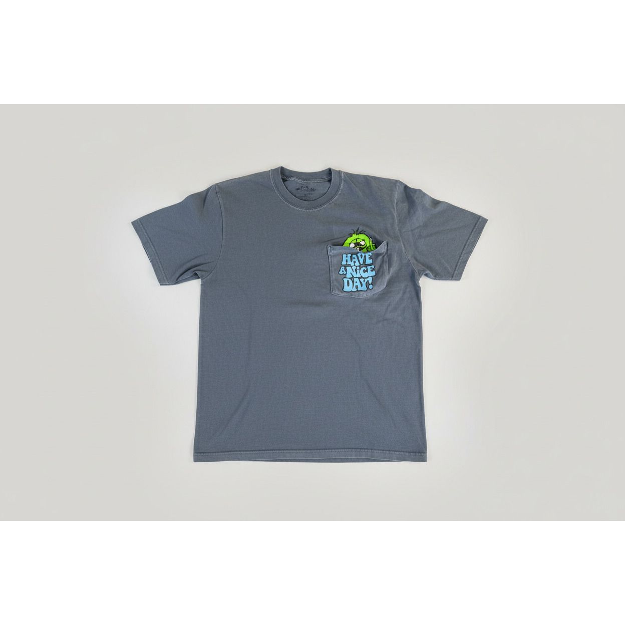 Gray shirt with a colorful graphic and text 'Have a nice day!' on the pocket.
